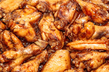 lots of fried chicken wings in a pan. close up
