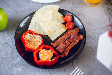 Arepa paisa with egg in paprika, bacon and tomato (Colombian breakfast)