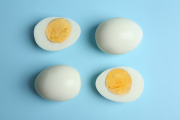 Fresh hard boiled chicken eggs on light blue background, flat lay