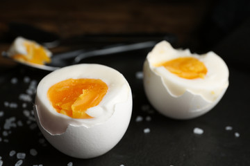 Tasty boiled chicken eggs on black slate plate, closeup