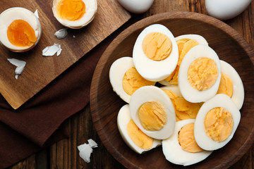 Tasty boiled chicken eggs on wooden table, flat lay