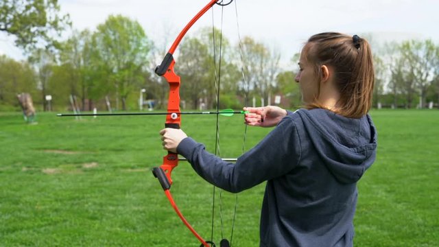 HD footage of girl shooting a bow and arrow at an archery range in slow motion