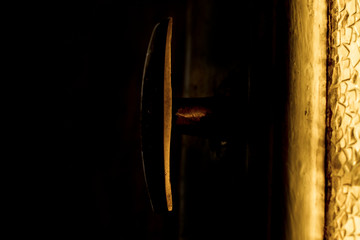 An old Handle and a yellow glass. Dark light view.