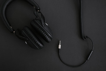 Headphones with wire on a black background.