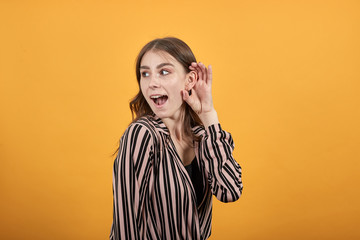 Cute Young Woman Light Brown In Striped Pink, Black Shirt On A Yellow Background, Focused Girl...