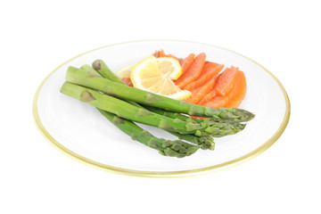 Tasty asparagus with salmon and lemon isolated on white