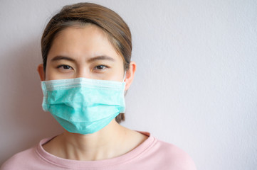Portrait of Asian woman wearing a surgical mask to protect against infectious diseases from virus or bad pollution from PM2.5. Conceptual of healthcare and medical condition, New normal lifestyle.