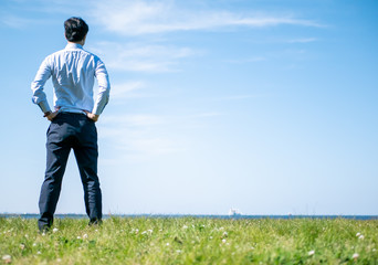 草原にビジネスマンが立っている