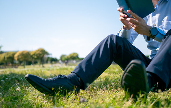 草原で本を読むビジネスマン