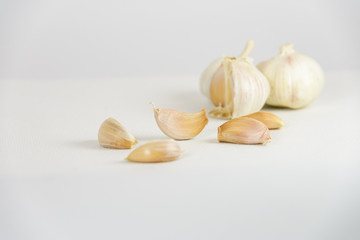 Fresh garlic head and garlic cloves on white canvas background with copy space. select focus
