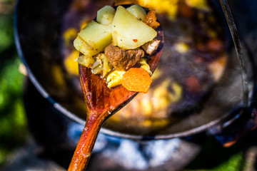 traditional Hungarian gulash soup (bogrács gulyás) in a pot over fire
