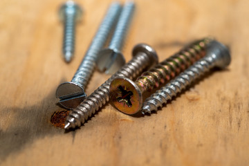 metal screws of different sizes on top of a pallet wood