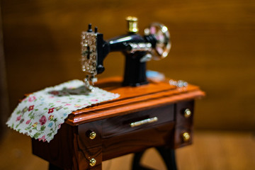 Fototapeta na wymiar Mini sewing machine with multi-colored threads around it