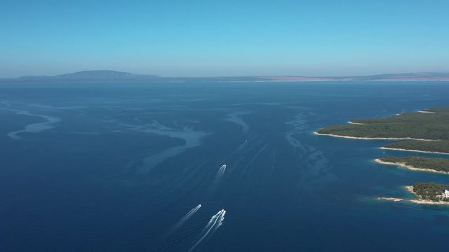 Beautiful aerial panoramic view of adriatic sea with turquoise coves and beaches on island of Rab, boats navigating, islands in background