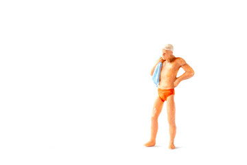Miniature people wearing swimsuit  standing on white background , Summer time concept