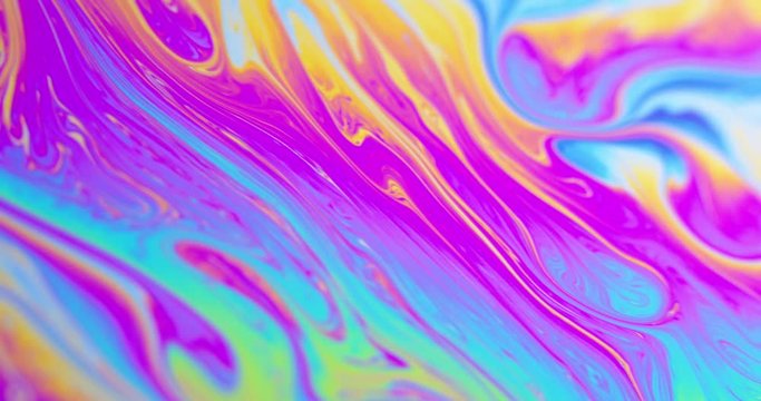 Surface of Liquid Soap with Changing Rainbow Colours. Macro.