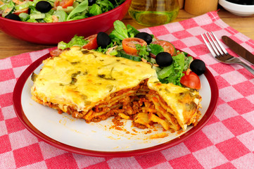 Slow cooked beef and pork ragu lasagne meal with fresh salad and olives