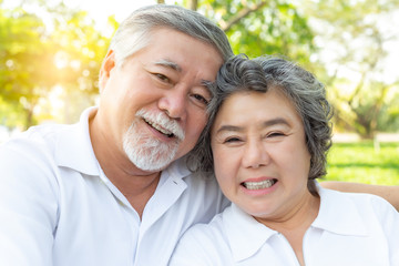 Close up portrait beautiful senior couple hugging, posing in spring park with happy, smile faces. Grandfather and grandmother relaxing. Charming elderly wife and husband have good health. health care