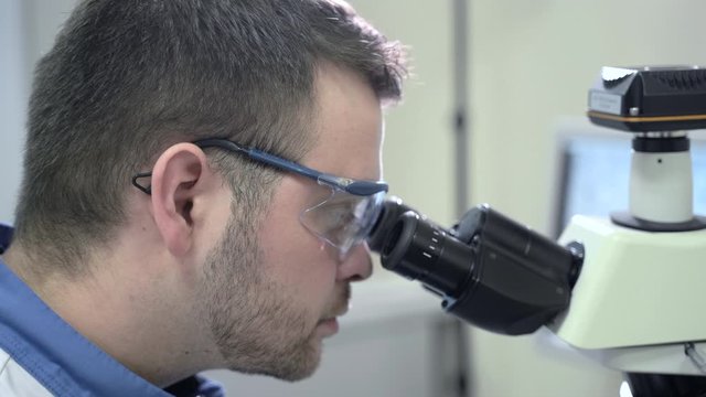 side view professional chemist wearing glasses examining virus covid-19 sample Spbas. learning, educating, analysis concept. male man scientist working in pharma laboratory
