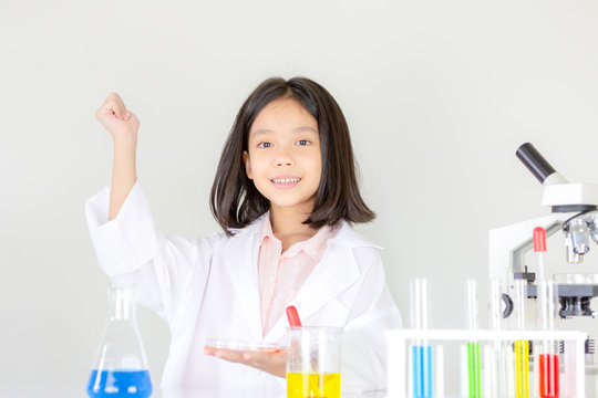 Children science concept, Happy little girl playing doing chemical experiments at the laboratory