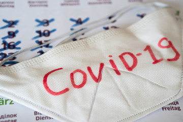 the respirator lies on calendar with marks. Concept of the raging coronavirus pandemic in 2020