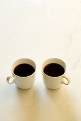 cups of coffees on white marble table in morning light