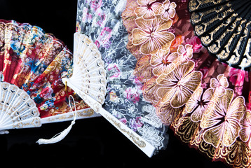 Flamenco hand fans with colorful pattern isolated on black  background. Spanish or Chinese influence