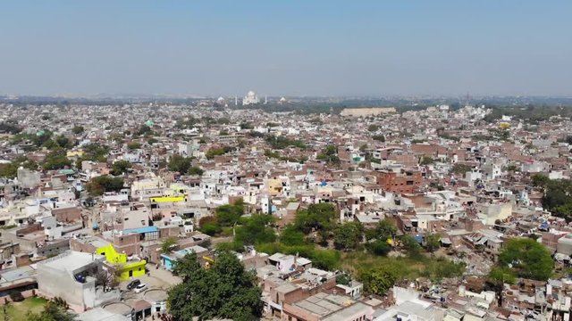 Flyover shot over Agra, India, with the Taj Mahal in the distance.