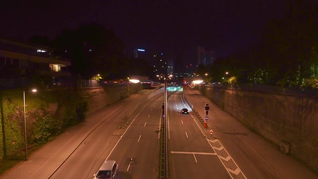 Timelapse of driving cars, traffic at night in Munich city, stop and go at the Effnerplatz with famous architecture elements.