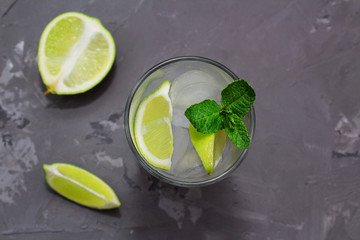 Home made cocktail mojoto in glass with lime, mint, ice, brown sugar on a gray background