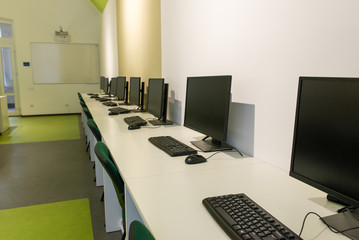 office room with computer tables with keyboard and mouse with a board and a projector