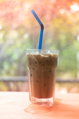 Iced Espresso coffee in a tall glass on wooden table.
