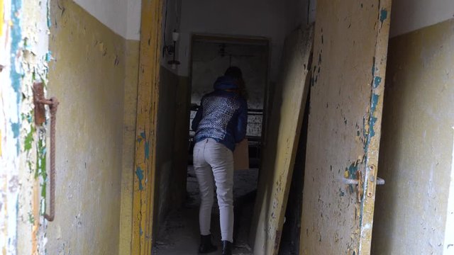 Girl is throwing stones in abandoned building