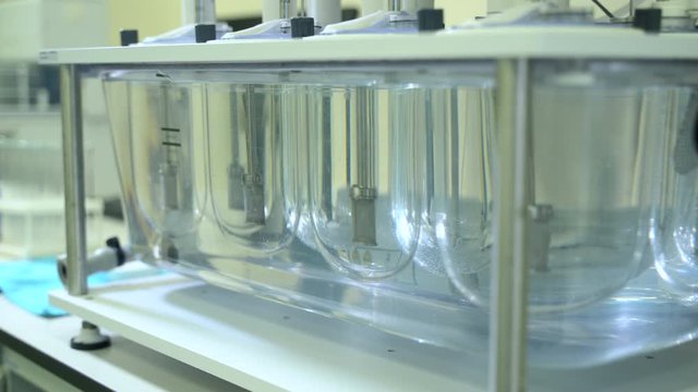 Automatic tablet disintegration and dissolution apparatus. Medication pills testing in laboratory spbas . Pharma industry, medicine and science concept. pharmaceutical equipment