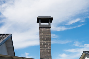 Obraz premium modern brick chimney pipe against a blue sky