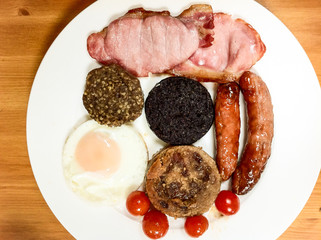 Schottisches Frühstück mit Ei, Tomaten, Schinken, Würstchen, Haggis und Black and White Pudding...