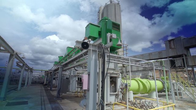 Industrial large-scale seawater pumping station with green heavy-duty pumps and massive pipelines. Cooling system for power plant or desalination facility in a coastal industrial area.