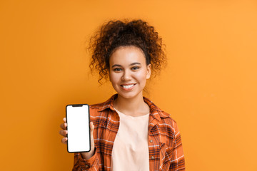 Beautiful young African-American woman with mobile phone on color background