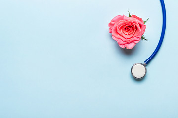 Beautiful rose heart and stethoscope on blue background. Thank you doctor and nurse day concept