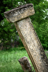 Old cemetery from the XVI-XIX century, old cemetery in Serbia in the village of Rajac, tombstones in the shape of a pillar with stone caps and decorations in the shape of a cross and a swastika