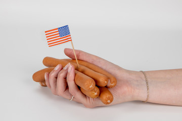 Weibliche Hand hält Wiener Würstchen mit USA Flagge