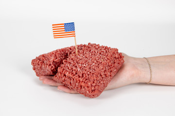 Weibliche Hand hält rohes Hackfleisch mit USA Flagge