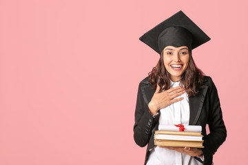 Female graduating student with diploma and books on color background