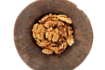 Walnuts in antique, wooden mortar.