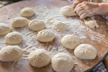 Fototapeta na wymiar Female hands kneading dough on wooden table