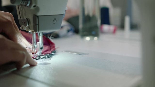 Close up of industrial sewing machine, tailor made fabrics sewing together, slow