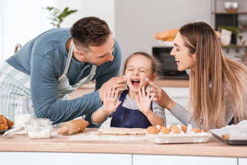 Happy family making dough together in kitchen