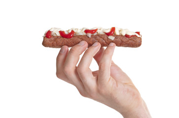 One frikadel with ketchup, mayonnaise on chopped onions, a Dutch fast food snack called 'frikadel...