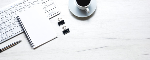 White desk office with laptop, smartphone and other work supplies with cup of coffee. Top view with copy space for input the text. Designer workspace on desk table essential elements on flat lay