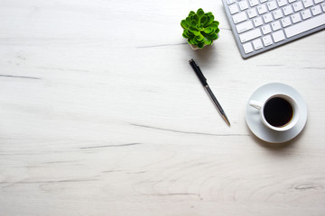 White desk office with laptop, smartphone and other work supplies with cup of coffee. Top view with...